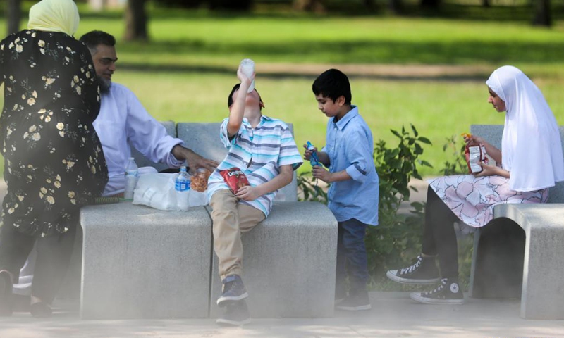 A boy cools off with an iced drink in Flushing Meadows Corona Park in New York, the United States, Aug. 13, 2021. A heat wave recently hit New York City.Photo:Xinhua