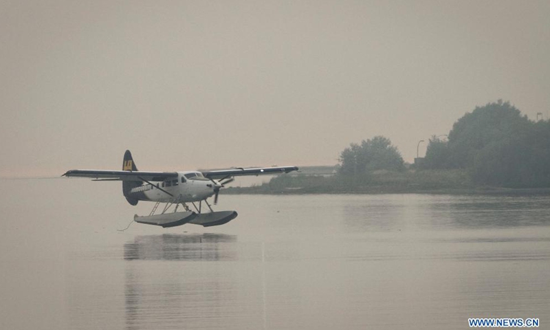 A seaplane is about to land on water under the smoky sky in Vancouver, British Columbia, Canada, Aug. 13, 2021. Vancouver was shrouded in smoke haze on Friday due to wildfires.Photo:Xinhua