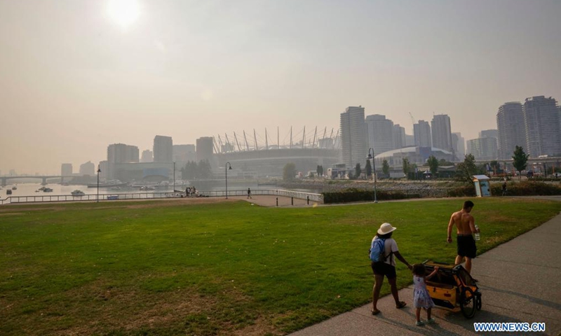 People walk at a park under the smoky sky in Vancouver, British Columbia, Canada, Aug. 13, 2021. Vancouver was shrouded in smoke haze on Friday due to wildfires.Photo:Xinhua