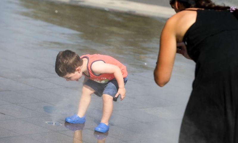 A boy cools off in the mist garden near the Unisphere in Flushing Meadows Corona Park in New York, the United States, Aug. 13, 2021. A heat wave recently hit New York City.Photo:Xinhua