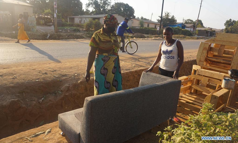 Beatrice Nanyangwe (R, Front), a female carpenter, shows a couch to a customer in Ndola, capital of Copperbelt province, Zambia, on Aug. 7, 2021. Nanyangwe, who is based in Ndola's Chipulukusu compound, has been making a range of furniture pieces for over a year, something she embarked on after undergoing training in carpentry and joinery at a correctional facility few years ago in Lusaka, the Zambian capital.(Photo: Xinhua)