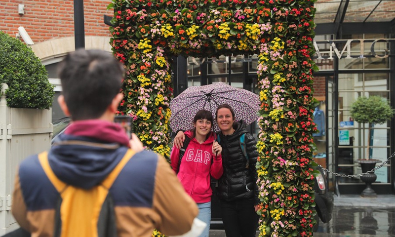 People pose for photos at a flower installation in central Brussels, Belgium, on Aug. 17, 2021.(Photo: Xinhua)