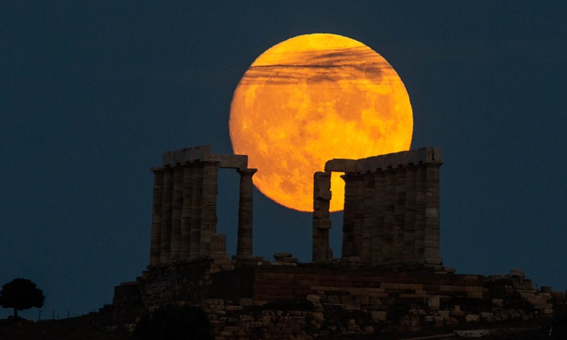 A full moon is seen over the Temple of Poseidon at cape Sounion, some 70 km southeast of Athens, Greece, on Aug. 21, 2021.(Photo: Xinhua)