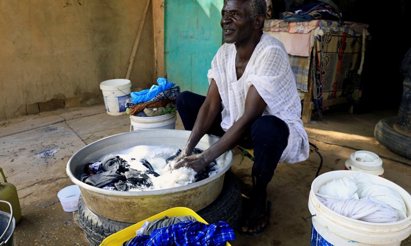 Photo taken on Aug. 24, 2021 shows a Sudanese man hand-washing clothes for his customers in the Sudanese capital of Khartoum.(Photo: Xinhua)