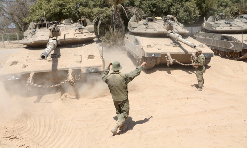 Israeli soldiers stand in front of their tanks near the Israel-Gaza border on Aug. 25, 2021.(Photo: Xinhua)