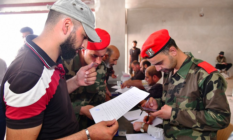 Armed men settle their criminal records with Syrian military police in Daraa province, southern Syria, on Sept. 1, 2021.(Photo: Xinhua)