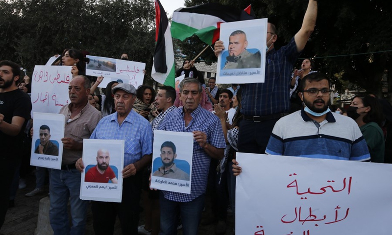 Protesters hold posters of the six Palestinian militants, who escaped from an Israeli prison, during a demonstration to show their support in Nazareth, Israel, on Sept. 11, 2021.(Photo: Xinhua)