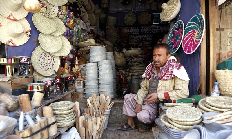 A seller of Yemeni traditional handicrafts sits in front of his shop in the Old City of Sanaa, capital of Yemen, on Sept. 27, 2021. (Photo: Xinhua)