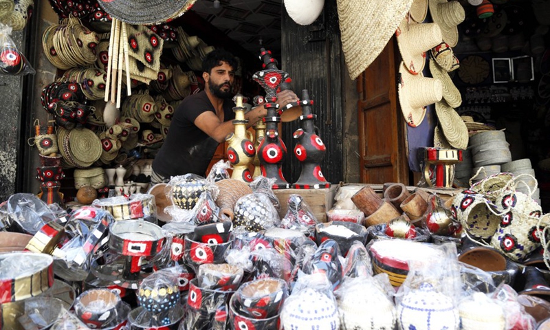 A seller of Yemeni traditional handicrafts stands inside his store in the Old City of Sanaa, capital of Yemen, on Sept. 27, 2021. (Photo: Xinhua)