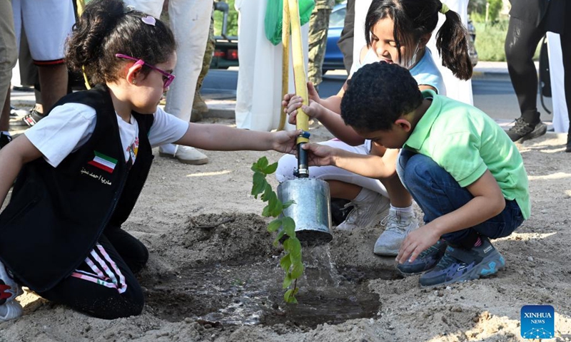 Children water a sapling during a tree-planting campaign in Capital Governorate, Kuwait, on Oct. 2, 2021. Kuwait launched on Saturday a tree-planting campaign in the Capital Governorate in an endeavor to address climate challenges.(Photo: Xinhua)