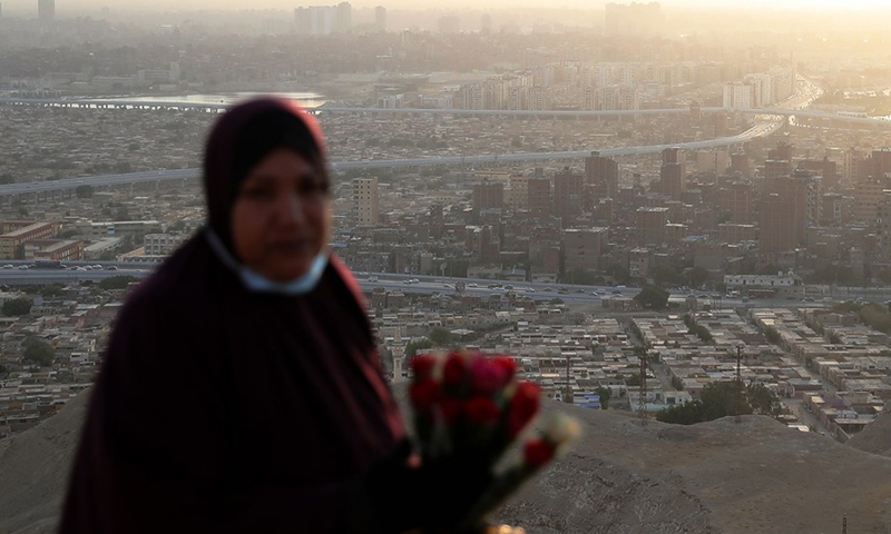 A woman sells roses to tourists at the Mokattam Corniche in Cairo, Egypt, on Oct. 17, 2021.(Photo: Xinhua)