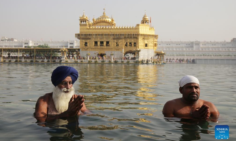 Devotees take a holy dip in the sacred pond of the Golden Temple, the holiest of Sikh shrines, on the occasion of the birth anniversary of the fourth Sikh Guru in Amritsar of India's northern state of Punjab, Oct. 22, 2021.Photo:Xinhua