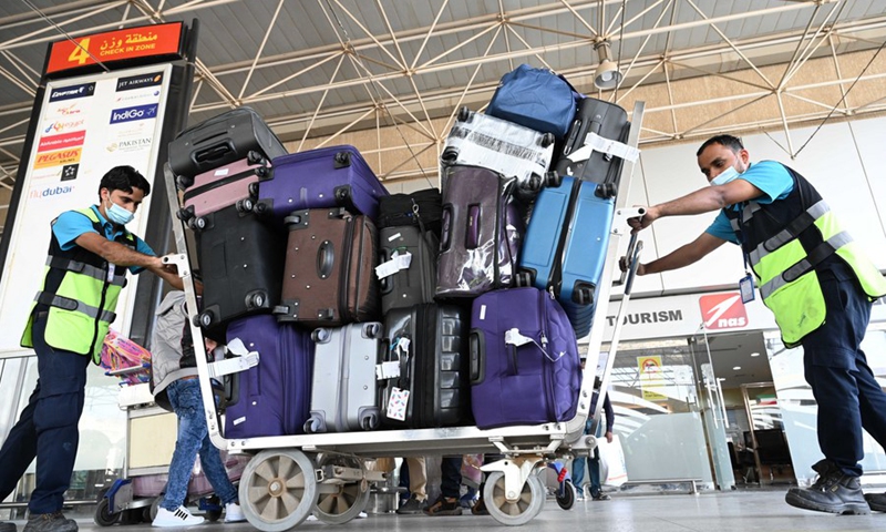 Airport employees transport passengers' baggage at Kuwait International Airport in Farwaniya Governorate, Kuwait, Oct. 24, 2021.(Photo: Xinhua)
