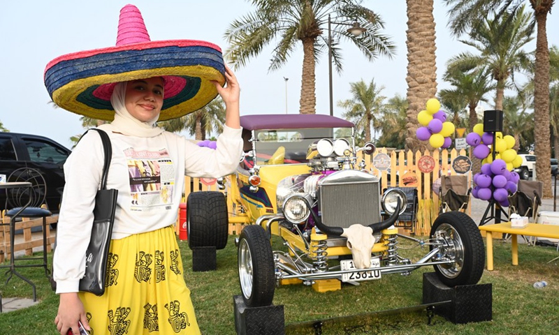 A woman poses at a classic car show in Hawalli Governorate, Kuwait, on Oct. 29, 2021.(Photo: Xinhua)