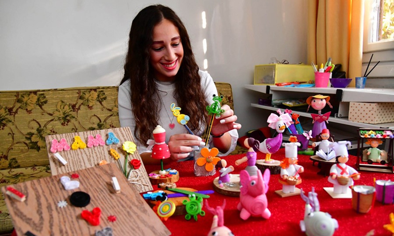 Sandra Baghdan, a fresh university graduate, makes small toys with recycled paper in Damascus, Syria on Nov. 4, 2021. (Photo: Xinhua)