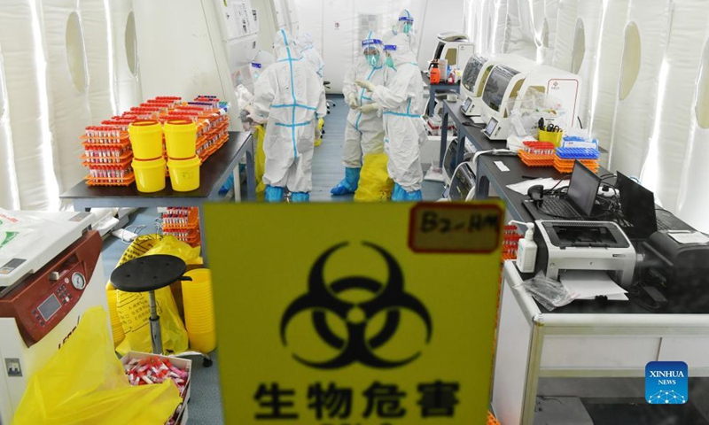 Medical workers work inside an air-inflated film chamber of a mobile laboratory for nucleic acid test in Harbin, northeast China's Heilongjiang Province, Nov. 5, 2021.Photo:Xinhua