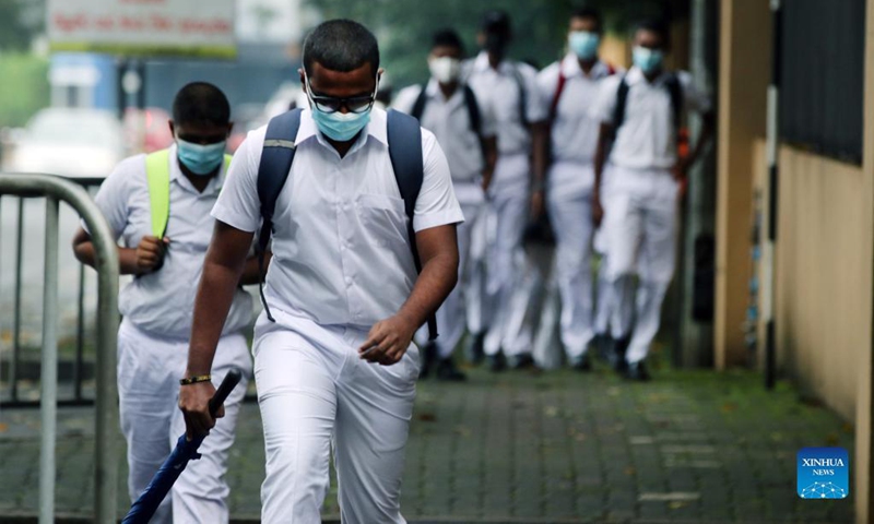 Students wearing face masks arrive at a school in Colombo, Sri Lanka, on Nov. 8, 2021. Academic activities in grades 10, 11, 12 and 13 in all schools across Sri Lanka resumed from Monday.(Photo: Xinhua)