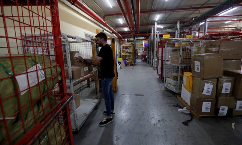 An Israeli worker checks an express parcel at the DHL sorting center in the Airport City near the central Israeli city of Tel Aviv on Nov. 11, 2021.(Photo: Xinhua)