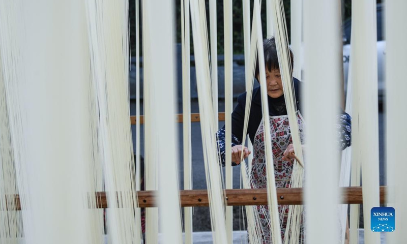 A villager dries handmade noodles in Huyuan Township of Fuyang District, Hangzhou City, east China's Zhejiang Province, Nov. 16, 2021. Noodle culture festival, noodle making activity, intangible cultural heritage performance and other events have been held in Huyuan Township in recent years, as efforts to promote the development of agricultural and rural tourism industries.  (Xinhua)