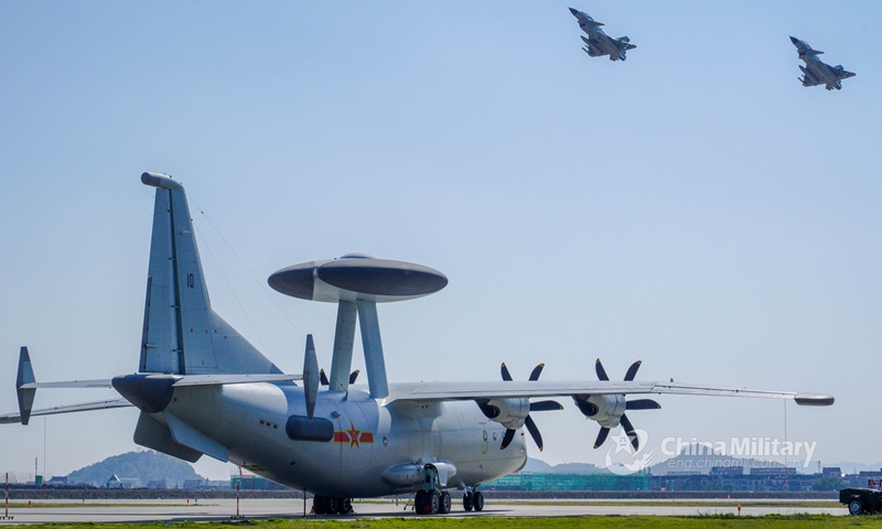 Two fighter jets attached to a naval aviation brigade under the PLA Eastern Theater Command soar into the air as a KJ-500 early-warning plane taxies on the flightline during a recent round-the-clock flight training exercise. (eng.chinamil.com.cn/Photo by Zhao Ningning and Shentu Linhui)