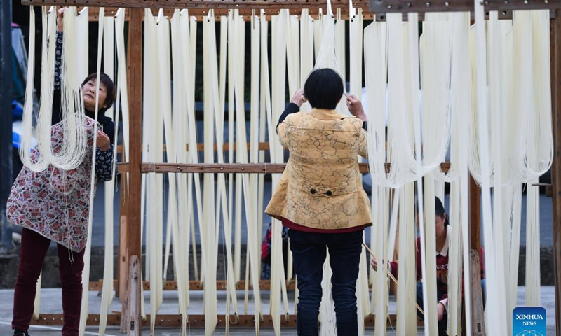 Villagers dry handmade noodles in Huyuan Township of Fuyang District, Hangzhou City, east China's Zhejiang Province, Nov. 16, 2021. Noodle culture festival, noodle making activity, intangible cultural heritage performance and other events have been held in Huyuan Township in recent years, as efforts to promote the development of agricultural and rural tourism industries.  (Xinhua)