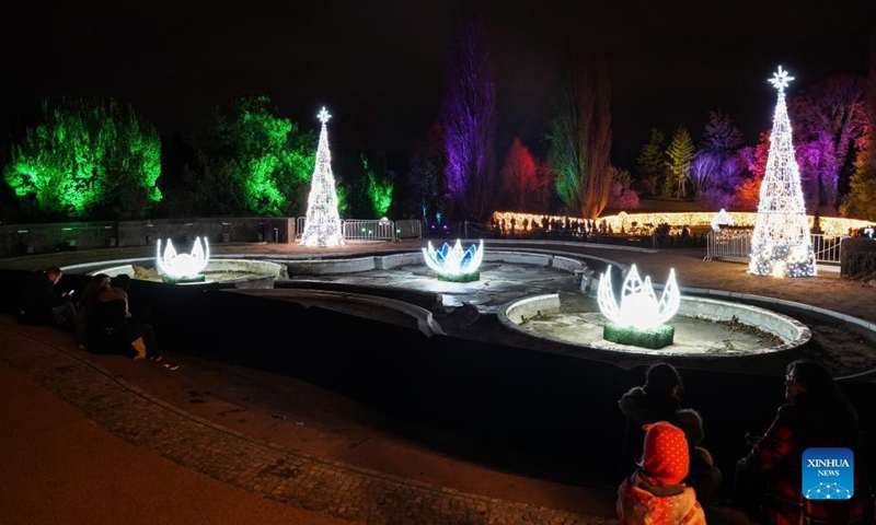 Visitors look at light decorations during the Christmas Garden Berlin light show at Berlin-Dahlem Botanical Garden in Berlin, capital of Germany, Nov. 19, 2021. The Christmas Garden Berlin kicked off on Friday and will last until Jan. 9, 2022. (Photo by Stefan Zeitz/Xinhua)