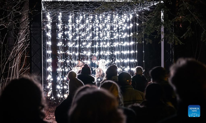 Visitors look at light decorations during the Christmas Garden Berlin light show at Berlin-Dahlem Botanical Garden in Berlin, capital of Germany, Nov. 19, 2021. The Christmas Garden Berlin kicked off on Friday and will last until Jan. 9, 2022. (Photo by Stefan Zeitz/Xinhua)