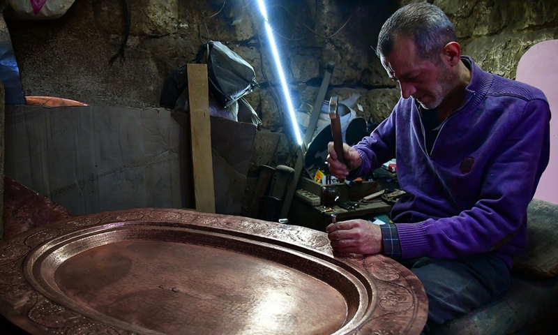 A craftsman makes copperware at a workshop in Damascus, Syria, on Nov. 28, 2021.(Photo: Xinhua)