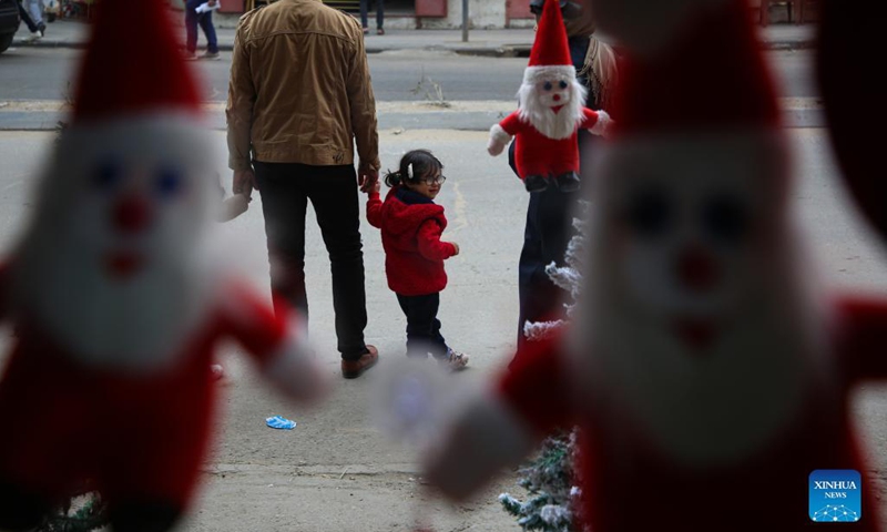 A Palestinian girl looks at Christmas decorations at a store in Gaza City, on Dec. 6, 2021.(Photo: Xinhua)