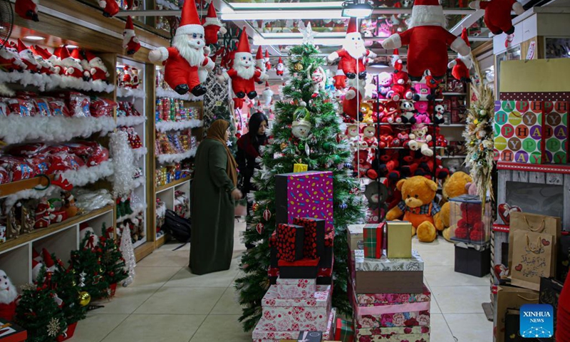 Palestinian women shop for Christmas decorations inside a store in Gaza City, on Dec. 6, 2021.(Photo: Xinhua)