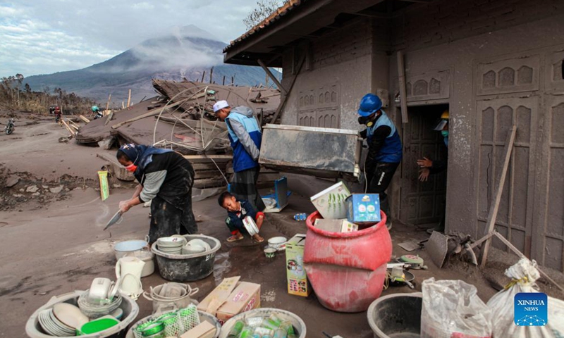 Volunteers help to move a cupboard from a house for cleaning after the Mount Semeru eruption in Sapiturang Village of Lumajang, East Java, Indonesia, Dec. 7, 2021. The death toll from the eruption of Mount Semeru has risen to 34, according to a local official.(Photo: Xinhua)