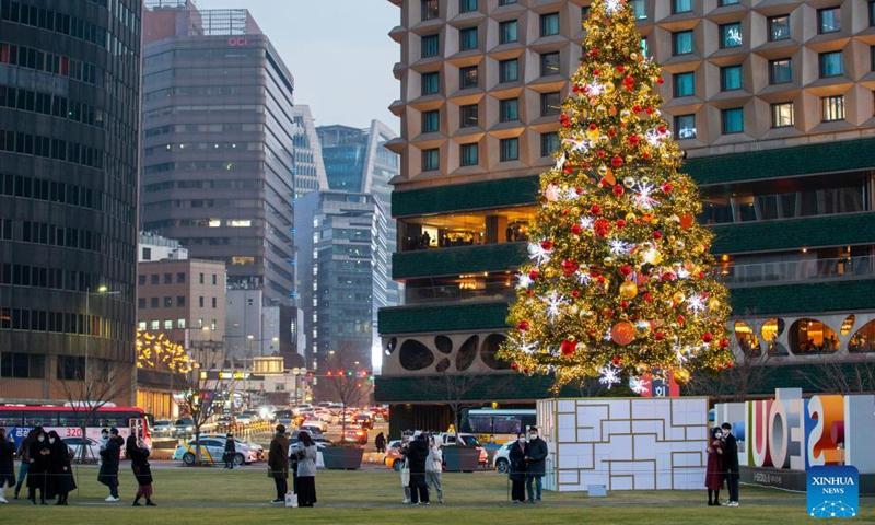 People pose with Christmas tree decorations in Seoul, South Korea, Dec. 11, 2021.Photo:Xinhua