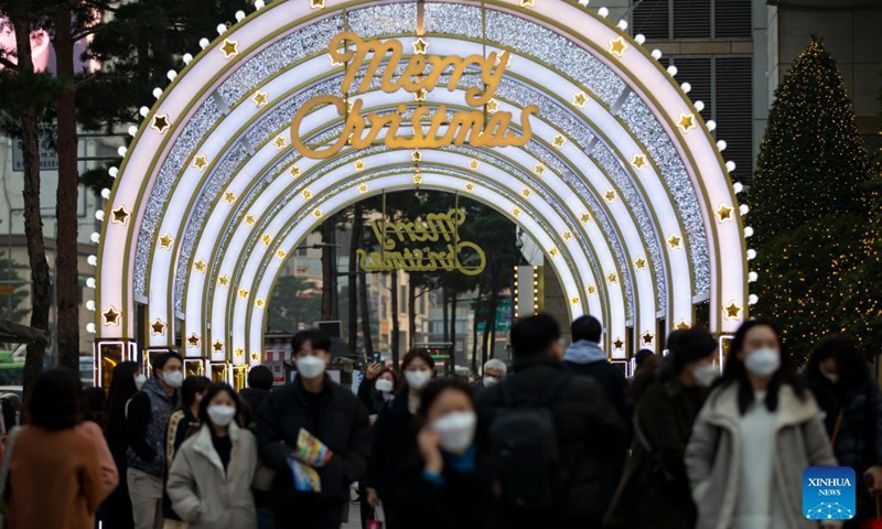 People walk past Christmas light decorations in Seoul, South Korea, Dec. 11, 2021.Photo:Xinhua