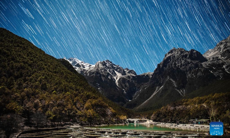 Photo taken on Dec. 14, 2021 shows a meteor of Geminids meteor shower at the Yulong Snow Mountain in Lijiang City, southwest China's Yunnan Province. The Geminids meteor shower of 2021 reached its peak on Tuesday.(Photo: Xinhua)