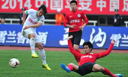 Xie Pengfei (left) of Hangzhou Greentown shoots against Ge Teng of Liaoning Whowin during their 10th-round Chinese Super League match in Panjin, Northeast China's Liaoning Province on Sunday. Liaoning won 2-1, their first victory in five rounds. Photo: CFP