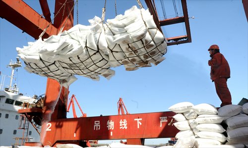 Packages of imported urea are unloaded from a ship Sunday in Lianyungang port, East China's Jiangsu Province. The price of urea dropped by 0.4 percent in mid-February from a year earlier, according to the National Development and Reform Commission. The agency also expects the price of fertilizer will grow only slightly this year because of increasing supply. Photo: CFP