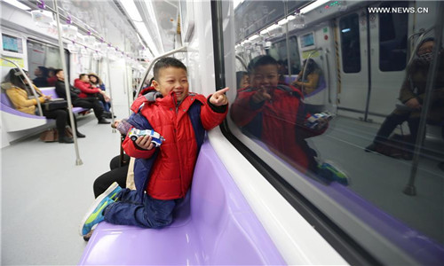 A boy plays in a train on Subway Line 4 in Nanjing, capital of east China's Jiangsu Province, Jan. 18, 2017. The 33.8-kilometer subway line started trial operation on Wednesday. (Xinhua/Wang Xin)