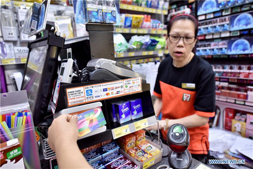 A customer uses Octopus card to buy products at a store in Hong Kong, south China, June 17, 2017. (Xinhua/Wang Xi)