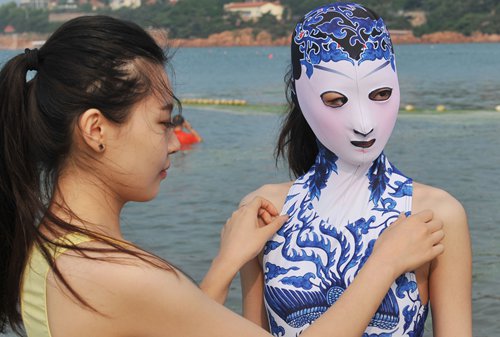 A model (right) wearing a facekini swimsuit featuring blue-and-white porcelain and embroidery is pictured at a beach resort in Qingdao city, East China's Shandong Province on Wednesday. Photo: IC