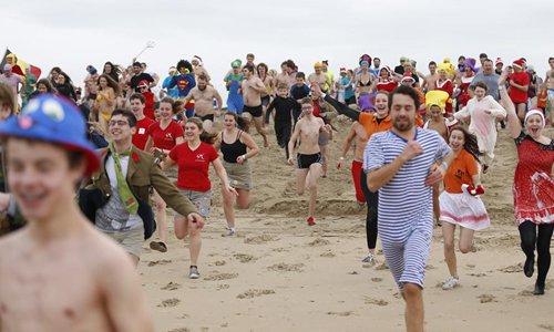 People take part in traditional New Year's dive at North Sea in Belgium ...