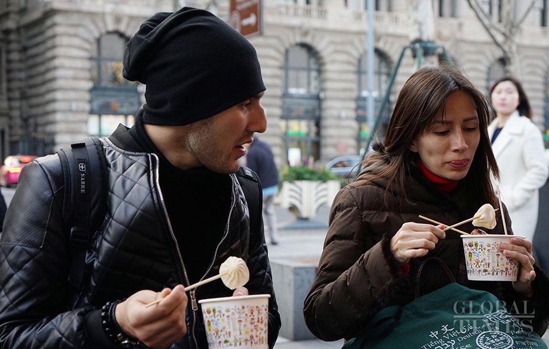 Overseas students try the local street food in Shanghai on Saturday. Photo: Chen Xia/GT