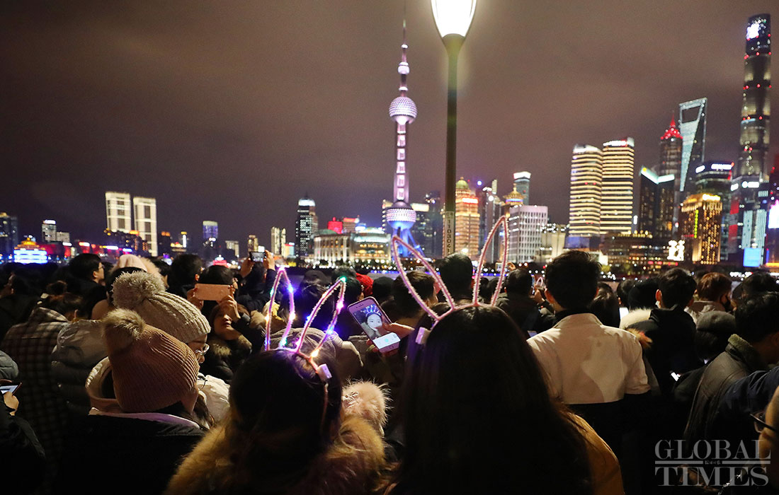 Tourists and local residents gather at Nanjing Road and the Bund in