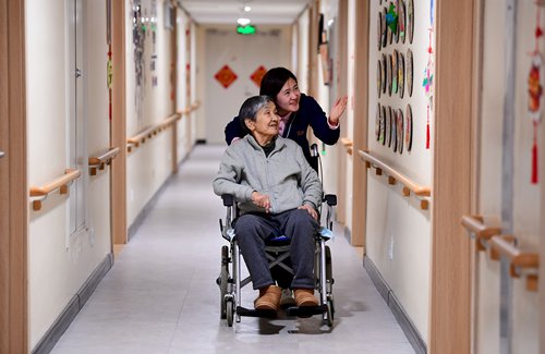 A young female caretaker attends to an old lady at an elder care facility in Shenyang, Northeast China's Liaoning Province, on Friday. Photo: VCG