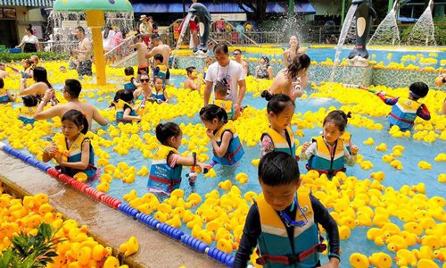 People have fun with yellow rubber ducks at Chimelong Water Park in ...