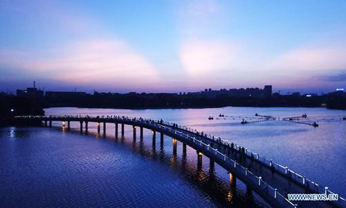 In this aerial photo taken on July 29, 2019, residents and tourists visit the Feicui Lake tourism resort to spend their leisure time at dusk in Hefei, east China's Anhui Province. (Xinhua/Zhang Duan) 