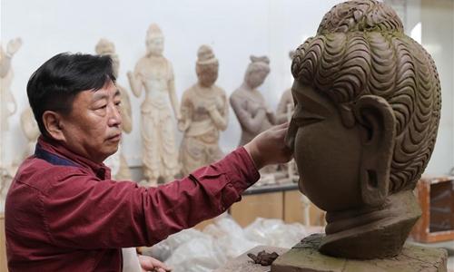 Painted sculpture artist Du Yongwei creates a clay model before painting in Dunhuang, northwest China's Gansu Province, April 5, 2020. Painted sculpture art is a traditional art form in Dunhuang and the craftsmanship has been inscribed in the provincial cultural heritage list of Gansu. Du Yongwei, 60, has been working in the field for over 40 years. He has started training class for youngsters to learn the art. (Xinhua/Du Zheyu) 