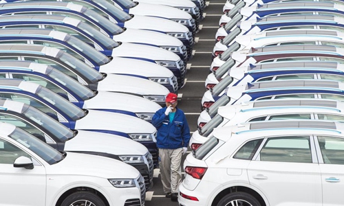 A worker checks Audi cars at FAW-Volkswagen vehicles' parking lot in Changchun, northeast China's Jilin Province, July 9, 2019. (Xinhua/Xu Chang)