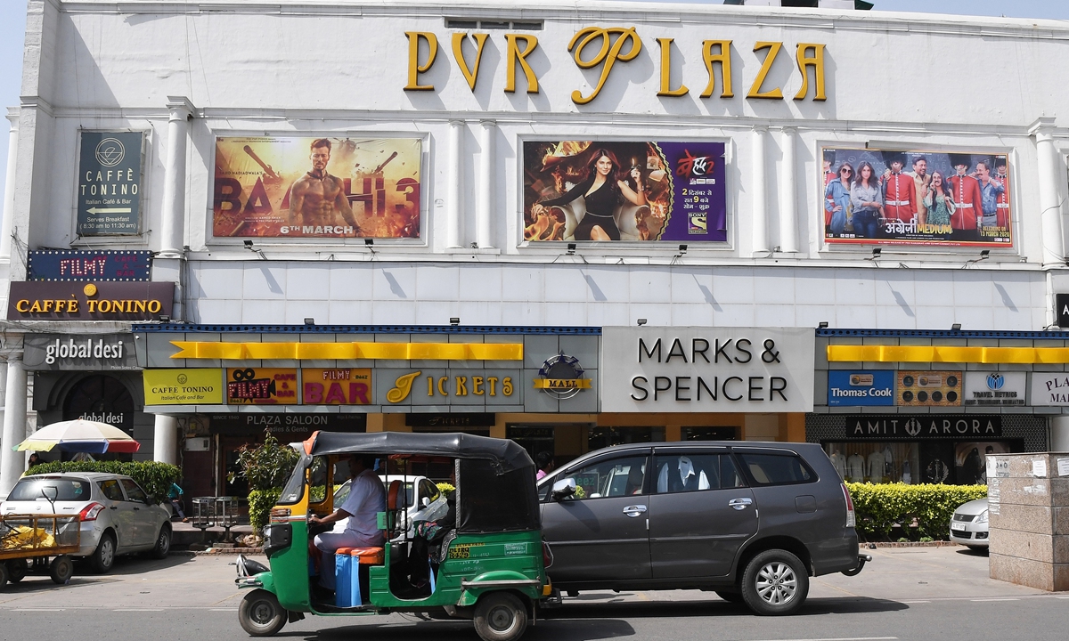 Vehicles drive past a closed PVR Plaza cinema complex in New Delhi on March 13. Photo: AFP