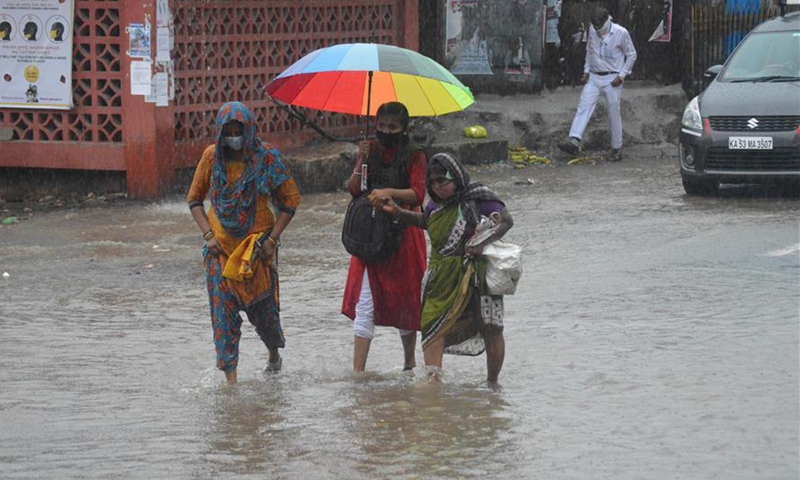 People walk during heavy rain in Bangalore, India - Global Times