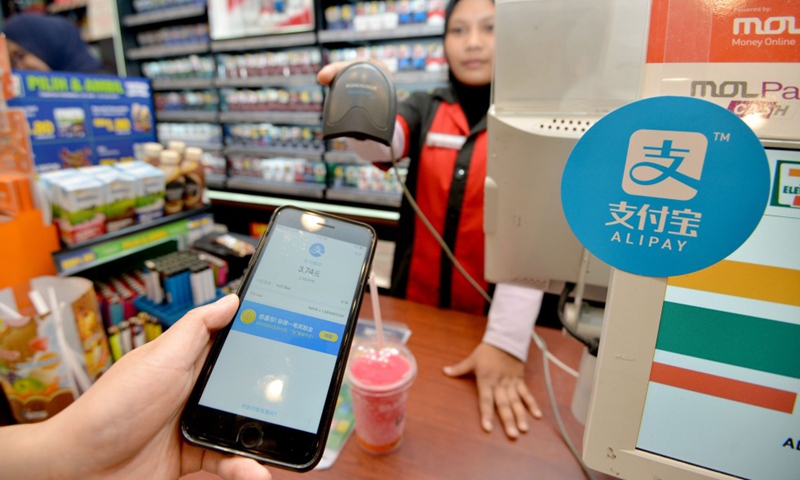 File Photo: A customer uses Alipay to pay for his pill at a shop in Kuala Lumpur, Malaysia, July 24, 2017. (Xinhua/Chong Voon Chung)